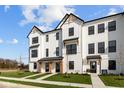 Attractive farmhouse style townhomes with contrasting black trim and beautifully landscaped front yards at 4150 Douro Trl, Westfield, IN 46062