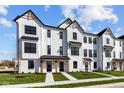 Charming modern farmhouse townhomes featuring black frame windows and well-manicured lawns at 4150 Douro Trl, Westfield, IN 46062