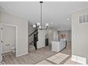 Open concept living space featuring a chandelier, stairs, and kitchen in the background at 4150 Douro Trl, Westfield, IN 46062