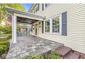 Inviting covered porch with stone flooring, seating, classic white columns, and views of the surrounding neighborhood at 4305 Central Ave, Indianapolis, IN 46205