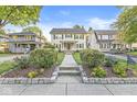 Traditional home with a well-manicured lawn, complemented by lush landscaping and a welcoming walkway to the front door at 4305 Central Ave, Indianapolis, IN 46205