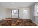 Bright living room featuring hardwood floors, a large window, and a white front door at 4623 Clark St, Anderson, IN 46013