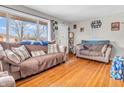 Bright living room featuring hardwood floors, neutral-toned sofas, and a large picture window for plenty of natural light at 606 Memorial Dr, Beech Grove, IN 46107