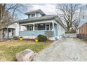 Quaint two-story blue house with charming front porch and inviting yellow door at 6179 Norwaldo Ave, Indianapolis, IN 46220