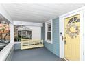 Inviting front porch with swing and yellow door at 6179 Norwaldo Ave, Indianapolis, IN 46220