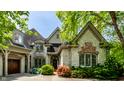 Stunning stone facade with brick accents, arched windows, and meticulously maintained landscaping at 6560 Dawson Lake Dr, Indianapolis, IN 46220