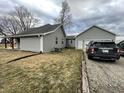 Exterior view of a house with a detached garage and long driveway, with a well-kept lawn at 8221 S 300 W, Muncie, IN 47302