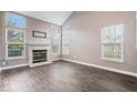 A cozy living room featuring a fireplace, multiple windows offering natural light, and hardwood flooring at 9571 Aberdare Dr, Indianapolis, IN 46250