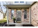 Inviting front porch with brick columns, decorative plants, and a stylish welcome mat at 9723 Innisbrook Blvd, Carmel, IN 46032