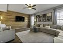 Spacious living room with hardwood floors, a ceiling fan, and a wood accent wall at 10326 Haag Dr, Brownsburg, IN 46112