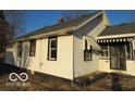Side view of a home with white siding, dark window trim, and striped awnings at 1310 E 5Th St, Muncie, IN 47302