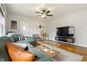Bright living room with hardwood floors, a green sofa, and a modern entertainment center at 23 Greenacre Dr, Brownsburg, IN 46112