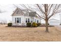 Beautiful two-story home with white siding, green roof, a lush yard, and detached garage at 3615 E State Rd 32, Lebanon, IN 46052
