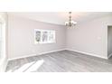 Bright, open living room with gray floors, chandelier lighting, and a large window at 59 E Troy Ave, Indianapolis, IN 46225