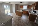 Eat-in kitchen features wood cabinets, an island, modern appliances, and sliding doors leading to the backyard at 6114 Arrowhead Dr, Anderson, IN 46013