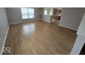 Sun-filled living room with beautiful wood-look flooring and a view into the kitchen at 6114 Arrowhead Dr, Anderson, IN 46013