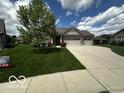 Attractive single-story home with a three-car garage, lush lawn, and beautiful landscaping features at 6117 Arctic Cir, Indianapolis, IN 46237