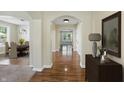 Inviting hallway with hardwood floors, arched doorways, and a view into the dining room at 6126 Golden Eagle Dr, Zionsville, IN 46077