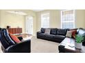 Comfortable living room features neutral carpet and a large leather sofa at 6126 Golden Eagle Dr, Zionsville, IN 46077