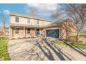 Attractive two-story home with a brick facade, covered porch, and a blue garage door at 6530 Grant Wood Ct, Indianapolis, IN 46256