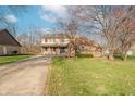Beautifully landscaped two-story home with a brick facade, covered porch, and a blue garage door at 6530 Grant Wood Ct, Indianapolis, IN 46256