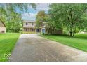 Expansive front lawn with mature trees framing a classic two-story home and a long driveway at 6530 Grant Wood Ct, Indianapolis, IN 46256
