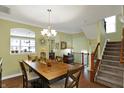Well-lit dining room showcasing hardwood floors, a chandelier, and a view of the staircase at 700 Greenford N Trl, Carmel, IN 46032
