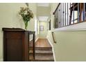 Entryway with hardwood floors, staircase, side table, vase with flowers, and light green walls at 700 Greenford N Trl, Carmel, IN 46032