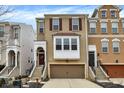 Charming brick townhome featuring a two-car garage, inviting entryway with steps, and eye-catching window shutters at 700 Greenford N Trl, Carmel, IN 46032
