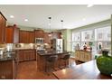 Kitchen featuring a center island, stainless steel appliances, dark wood cabinets, and granite counters at 700 Greenford N Trl, Carmel, IN 46032
