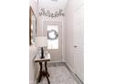 Charming foyer featuring a decorative table, a mirror, and a view of the glass-paned front door at 7221 Broyles Ln, Indianapolis, IN 46217