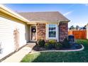 Inviting front entrance with brick accents, a decorative wreath on the door, and well-maintained landscaping at 7221 Broyles Ln, Indianapolis, IN 46217