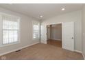 Bright bedroom with neutral carpet, a large window and French doors that add elegance at 7728 Solomon Dr, Zionsville, IN 46077