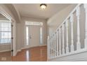 Inviting foyer with hardwood floors, white staircase and natural light from the front door at 7728 Solomon Dr, Zionsville, IN 46077