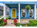 Inviting front porch with seating, colorful potted plants, and hanging ferns creating a warm welcome at 912 Harlan St, Indianapolis, IN 46203