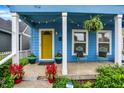 Cozy porch featuring a yellow door, potted plants, and string lights at 912 Harlan St, Indianapolis, IN 46203