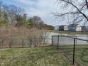 Scenic backyard featuring a peaceful pond with a chain link fence and gate at 1282 Highpointe Blvd, Shelbyville, IN 46176