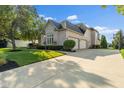 Long driveway leads to a three-car garage of a beautiful home with manicured lawn at 13499 Marjac Way, Fishers, IN 46055