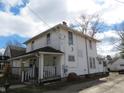 Two-story home featuring a front porch and a classic, timeless facade, on a partially sunny day at 159 E Washington St, Morgantown, IN 46160