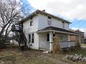 Two-story home with a classic front porch, complemented by an exterior metal staircase, and established yard at 159 E Washington St, Morgantown, IN 46160