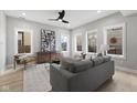Living room featuring a large art piece and gray sofa illuminated by natural light from several windows at 2406 Carrollton Ave, Indianapolis, IN 46205