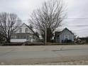 A quaint two-story home featuring a screened-in porch, nestled among mature trees with street view at 250 S Marion St, Morgantown, IN 46160