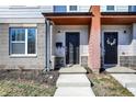 The townhouse entrance features a covered porch, modern black door, digital lock and exterior light at 3046 W New York St, Indianapolis, IN 46222