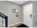 The foyer offers modern gray walls, a white front door, dark floors and a coat rack with mirror at 3046 W New York St, Indianapolis, IN 46222