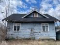 The back of this house exhibits weathered siding, framed windows, and a dark shingled roof at 3132 E 36Th St, Indianapolis, IN 46218