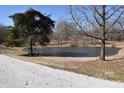 Scenic view of a serene pond, surrounded by mature trees and natural landscape at 3546 Stierwalt Rd, Quincy, IN 47456