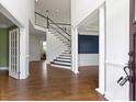 Spacious foyer featuring hardwood floors, staircase with white railing and adjacent formal rooms at 4520 Waterchase Ct, Zionsville, IN 46077