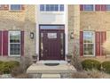Welcoming front entrance with a brick facade, featuring a decorative door, sidelights, and charming flowerpots at 4520 Waterchase Ct, Zionsville, IN 46077