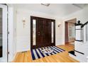 Elegant foyer with hardwood floors, wainscoting, decorative lighting and front door at 5109 Kingswood Dr, Carmel, IN 46033