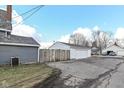 Detached two-car garage with white siding and a weathered wooden fence at 516 W Washington St, Lebanon, IN 46052